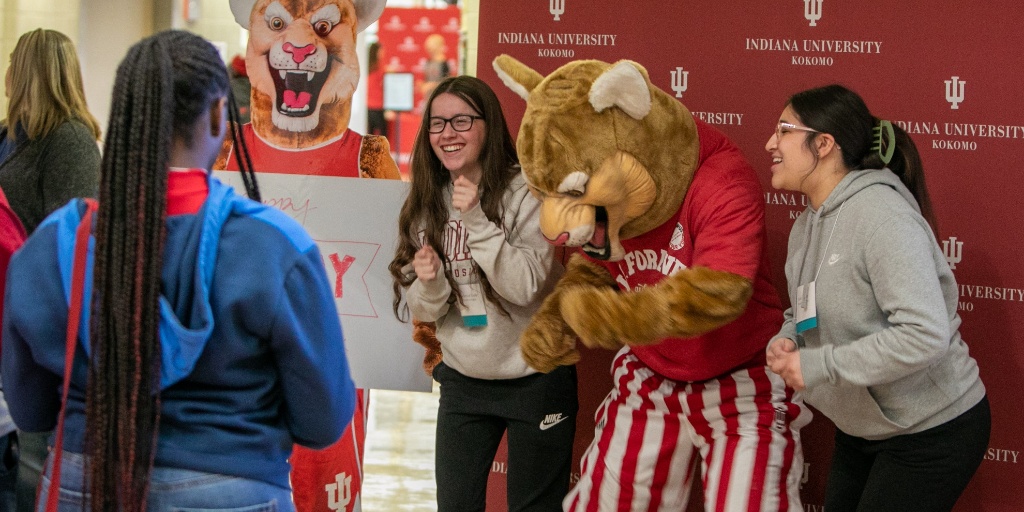 Two students standing with Kingston.